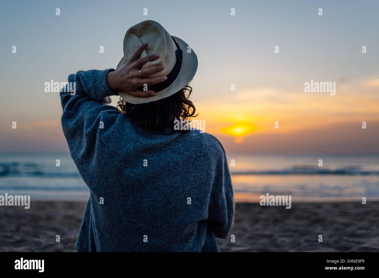 Unrecognizable young woman in hat enjoying sunset on the beach Stock ...