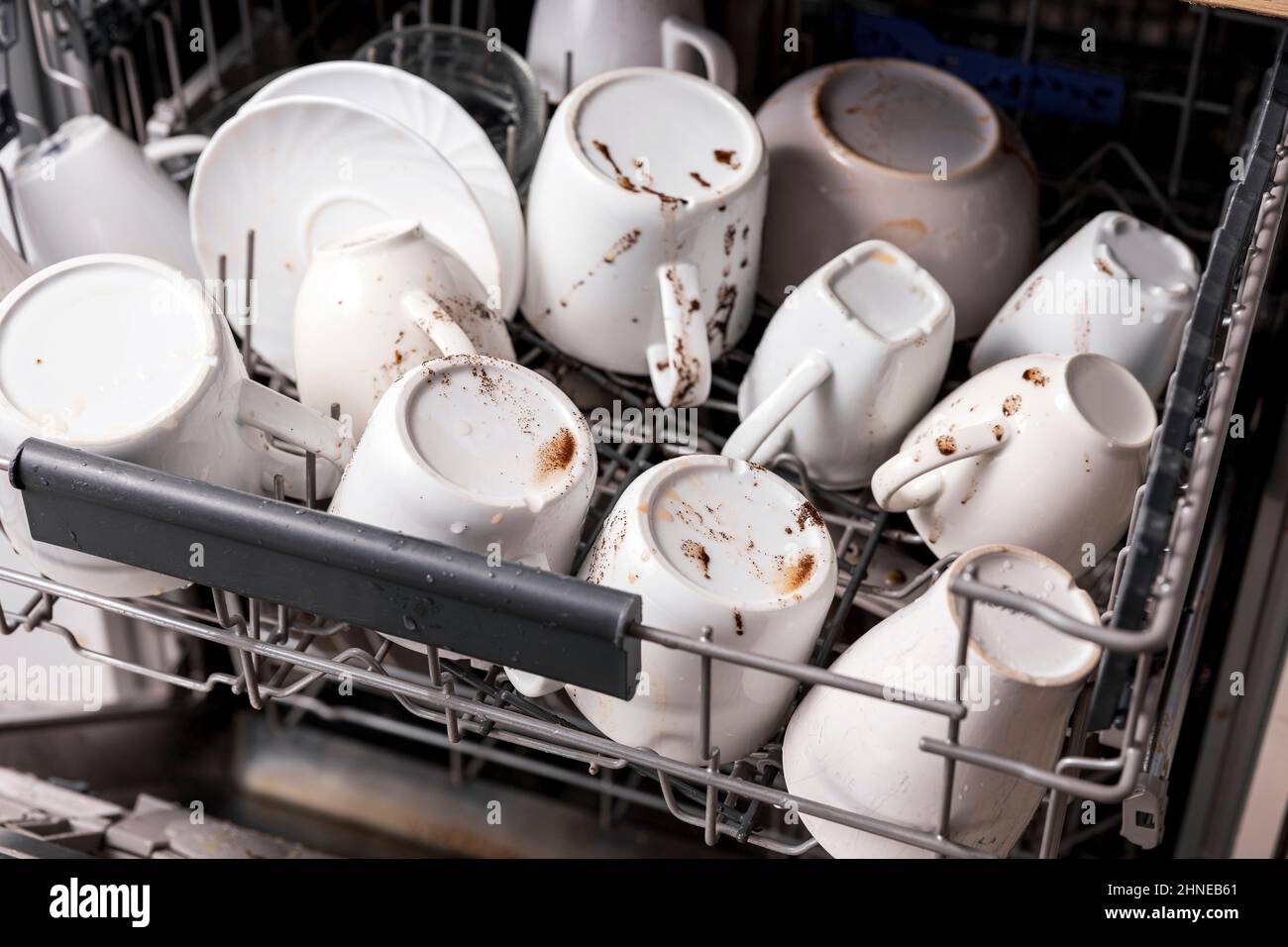 Unwashed, dirty dishes in dishwasher. Mess in the kitchen. Dirty