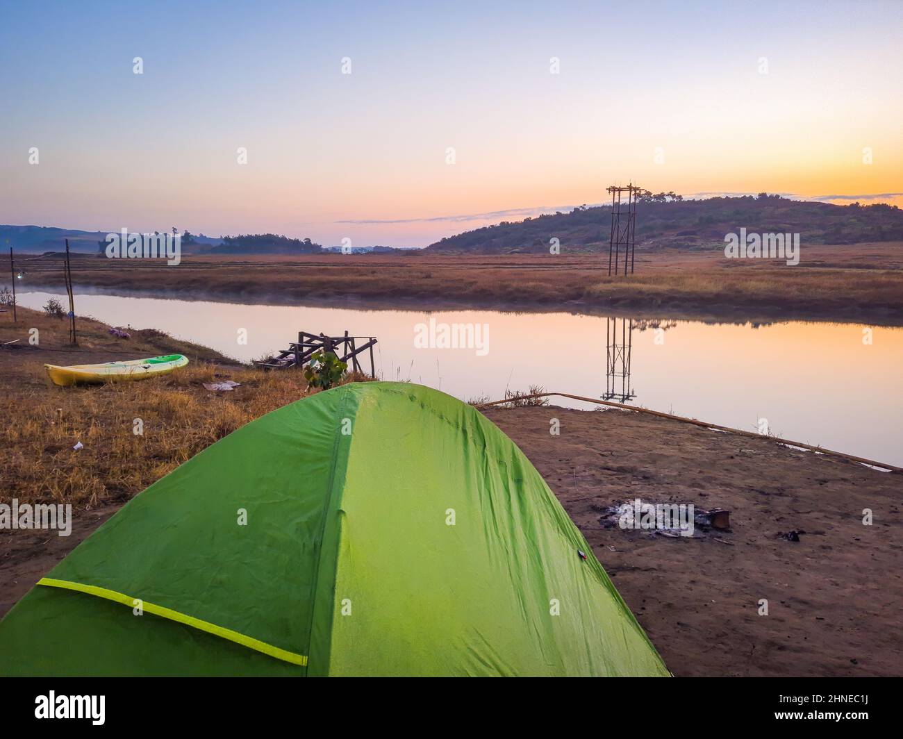 isolated camping tent at river edge leading to the mountain with ...