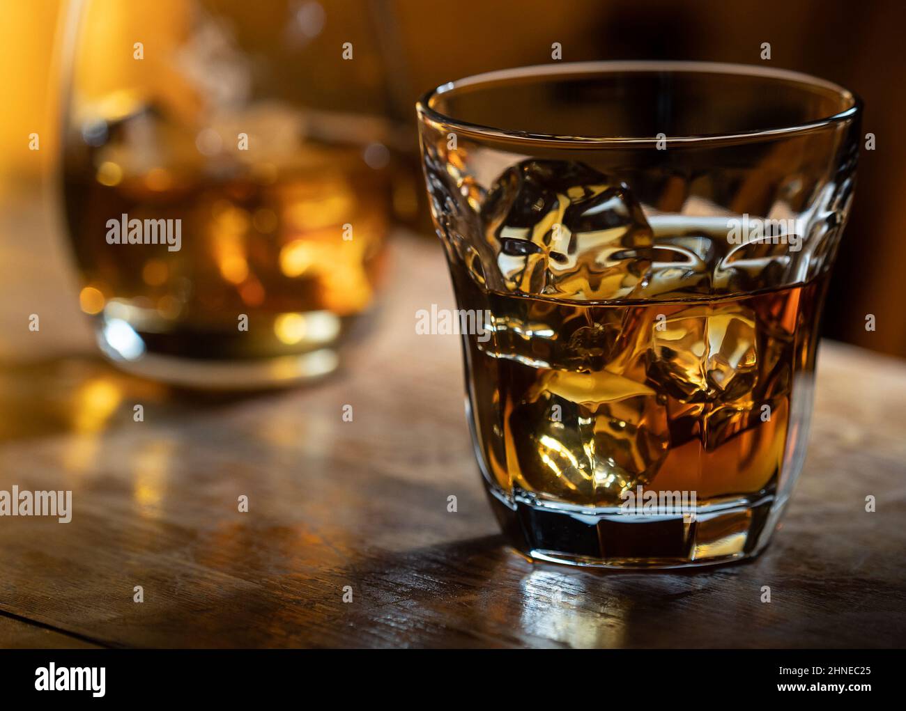 https://c8.alamy.com/comp/2HNEC25/glass-of-whisky-on-the-rocks-on-a-wooden-bar-top-2HNEC25.jpg