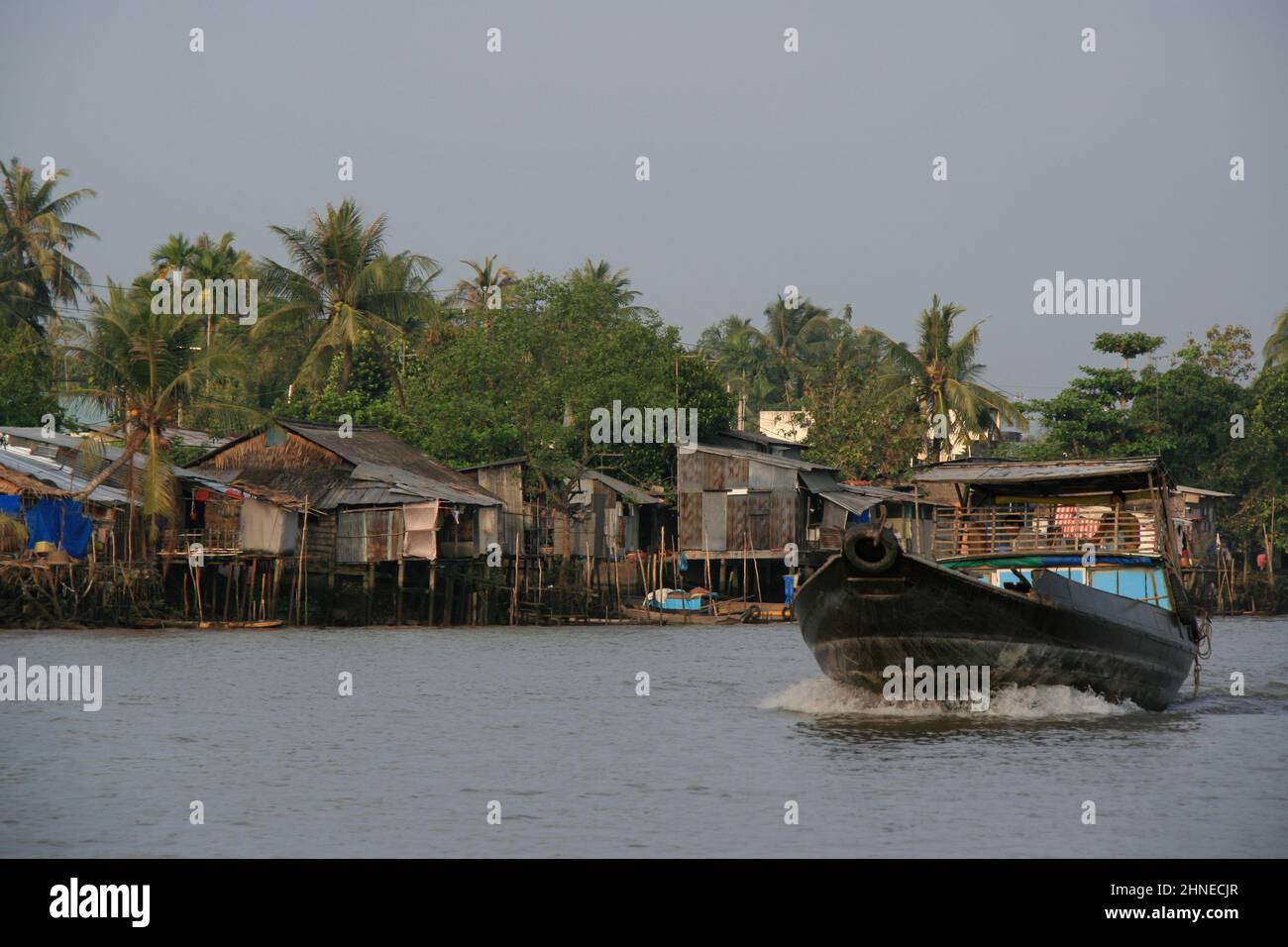 village and slum along a river in the delta of mekong in south vietnam ...