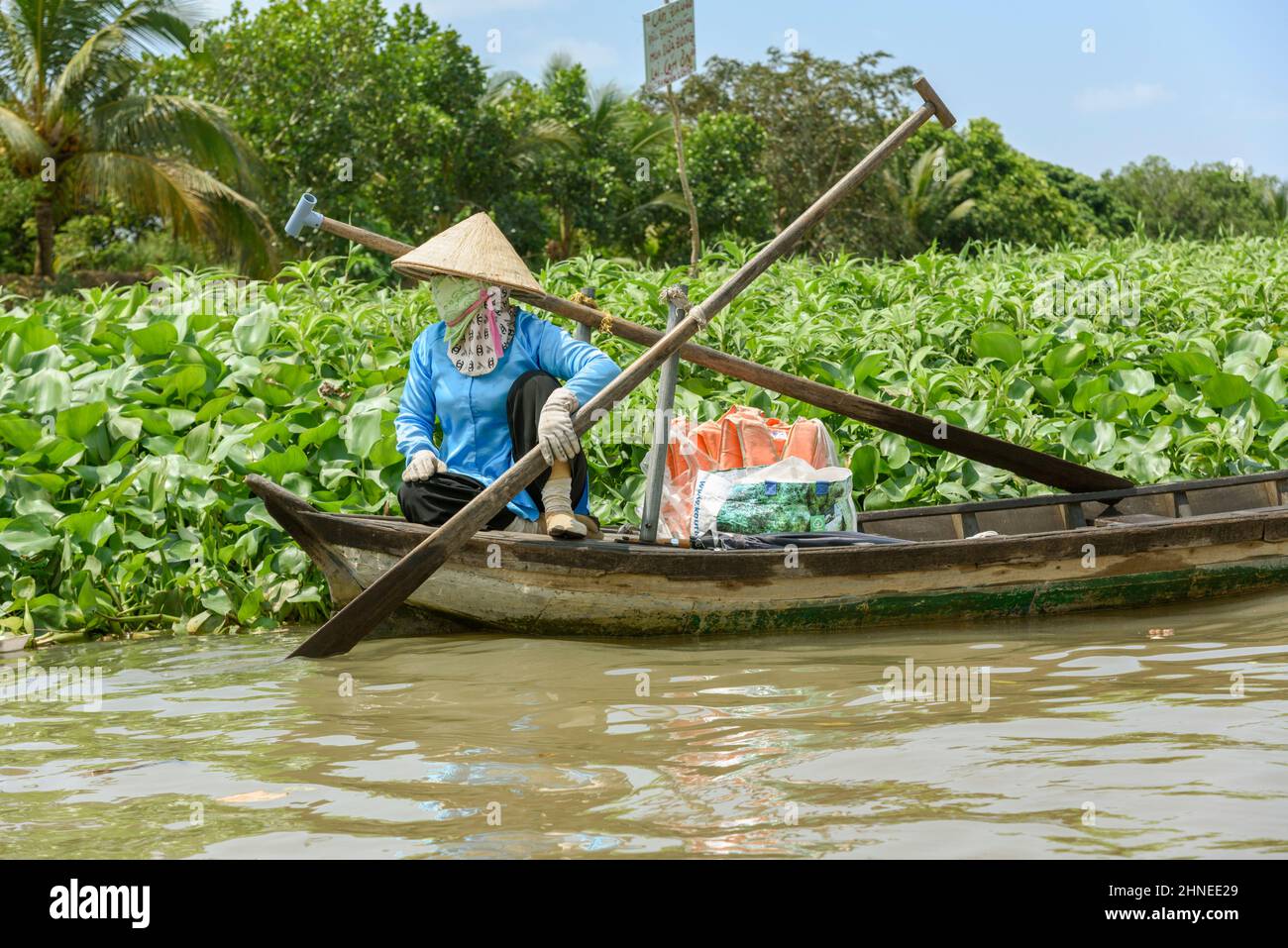 Vietnamese woman with a traditional wooden rowing boat (sampan) on the Mekong River, Mekong Delta, Vinh Long Province, southern Vietnam Stock Photo