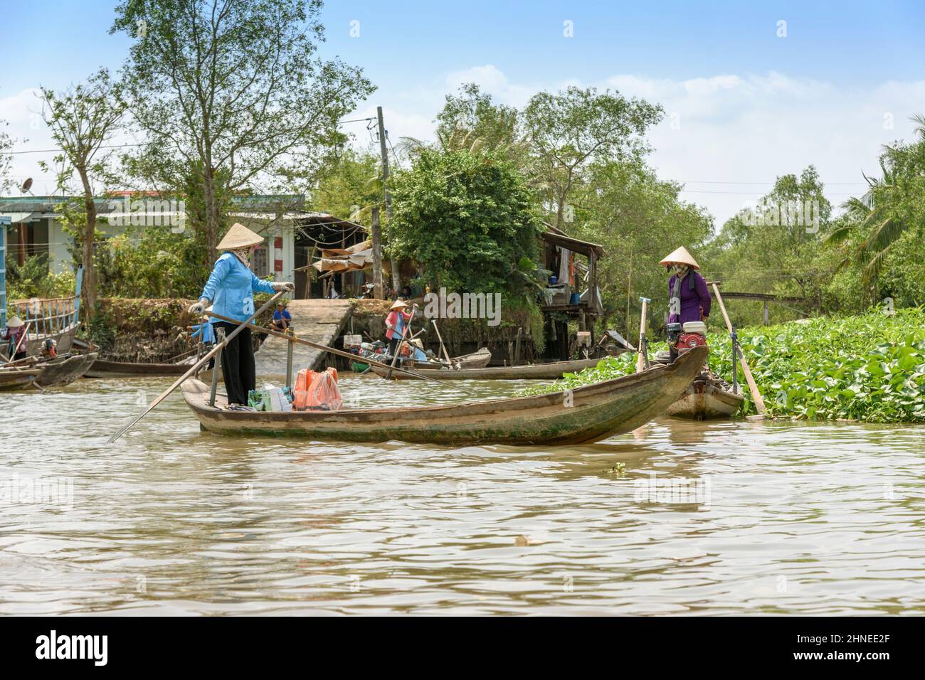 Vietnamese women with traditional wooden rowing boats (sampans) on the Mekong River, Mekong Delta, Vinh Long Province, southern Vietnam Stock Photo
