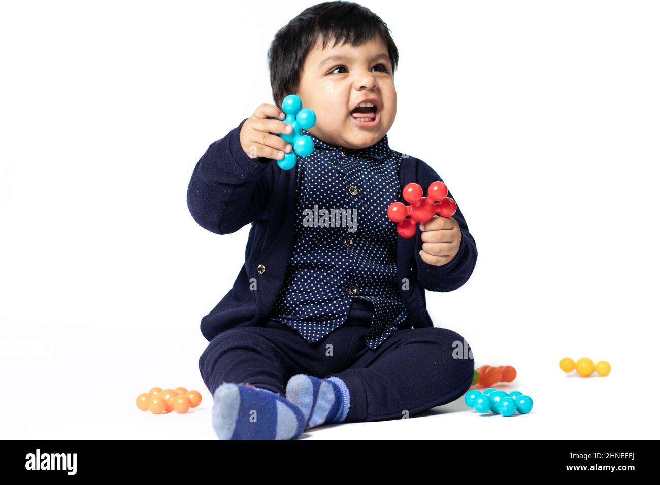 Happy Indian Toddler Playing With Colorful Toys Isolated On White Background. Fun, Activity, Educational, Kindergarten, Birthday, Learning, Home Activ Stock Photo