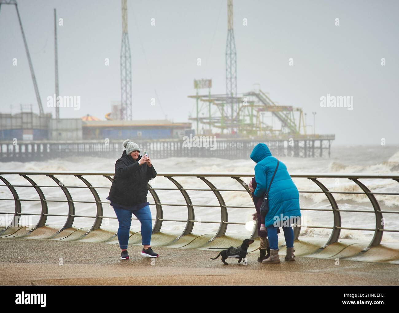 Storm Dudley,one of two storms hitting the UK arrives at Blackpool on the North West coast of England closely followed by storm Eunice 24 hours later,both bringing heavy rain and very strong winds. Taking pictures in front of rough sea Stock Photo