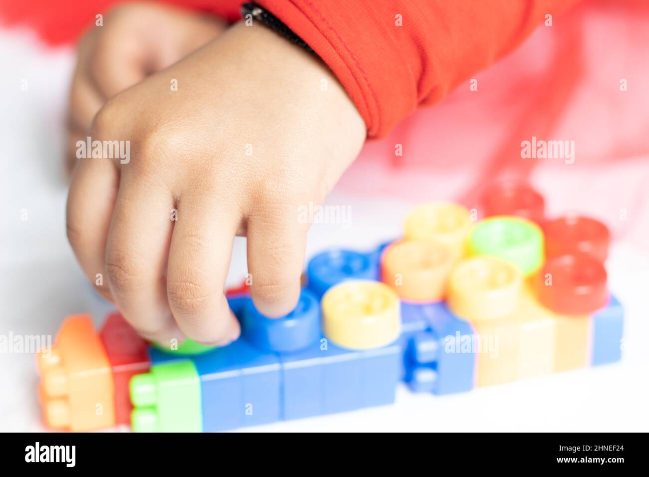 Nimble fingers Of Infant Toddler Kid Playing With Multicolored Building