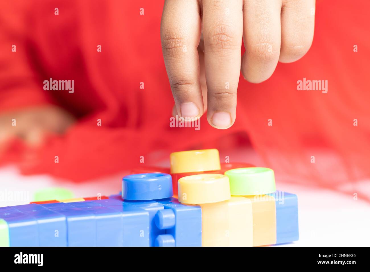 Nimble fingers Of Infant Toddler Kid Playing With Multicolored Building