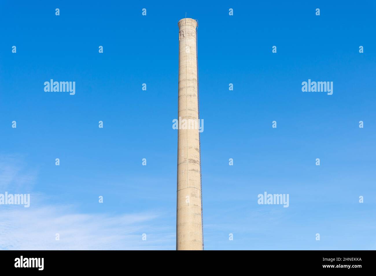 Old smoke stack with blue skies in the background. Stock Photo