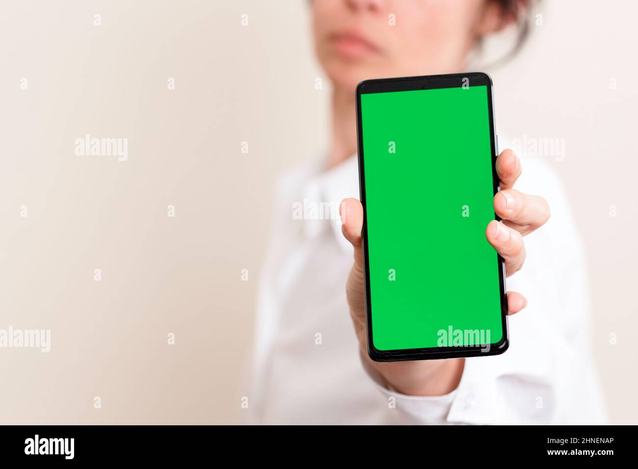 Woman hand holding smartphone with blank green screen background Stock ...