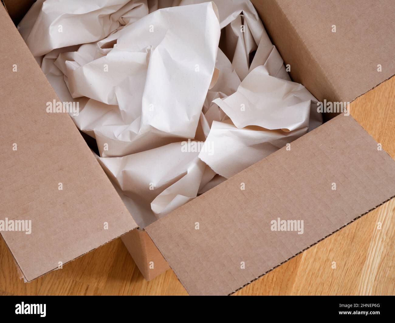 Crumpled paper in a cardboard box. Close up. Stock Photo