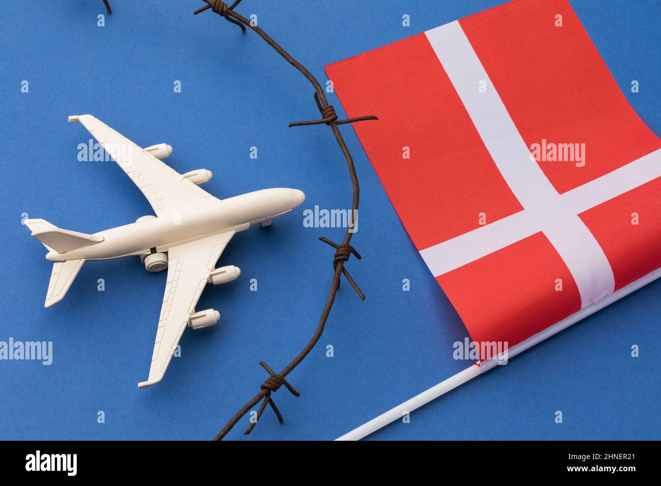 Toy plane, flag and barbed wire on colored background, Swedish air border violation concept Stock Photo