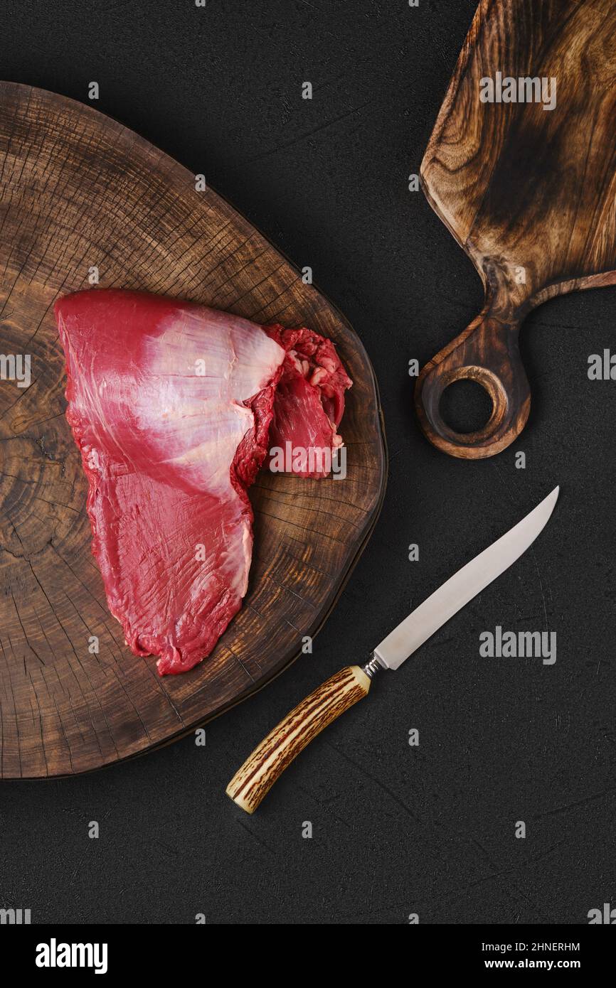 Top view of raw ribeye cap roll on wooden on chopping slab Stock Photo