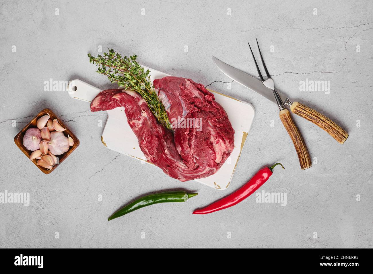 Raw beef whole tenderloin with herbs and spice on concrete background Stock Photo