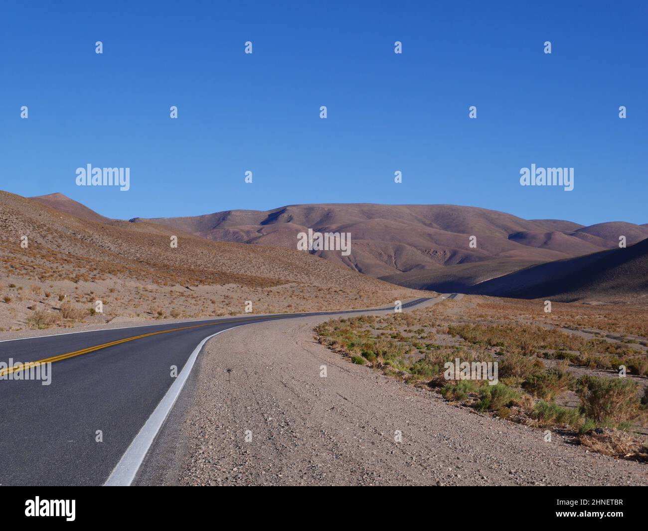 View of a long road through the desert Stock Photo - Alamy