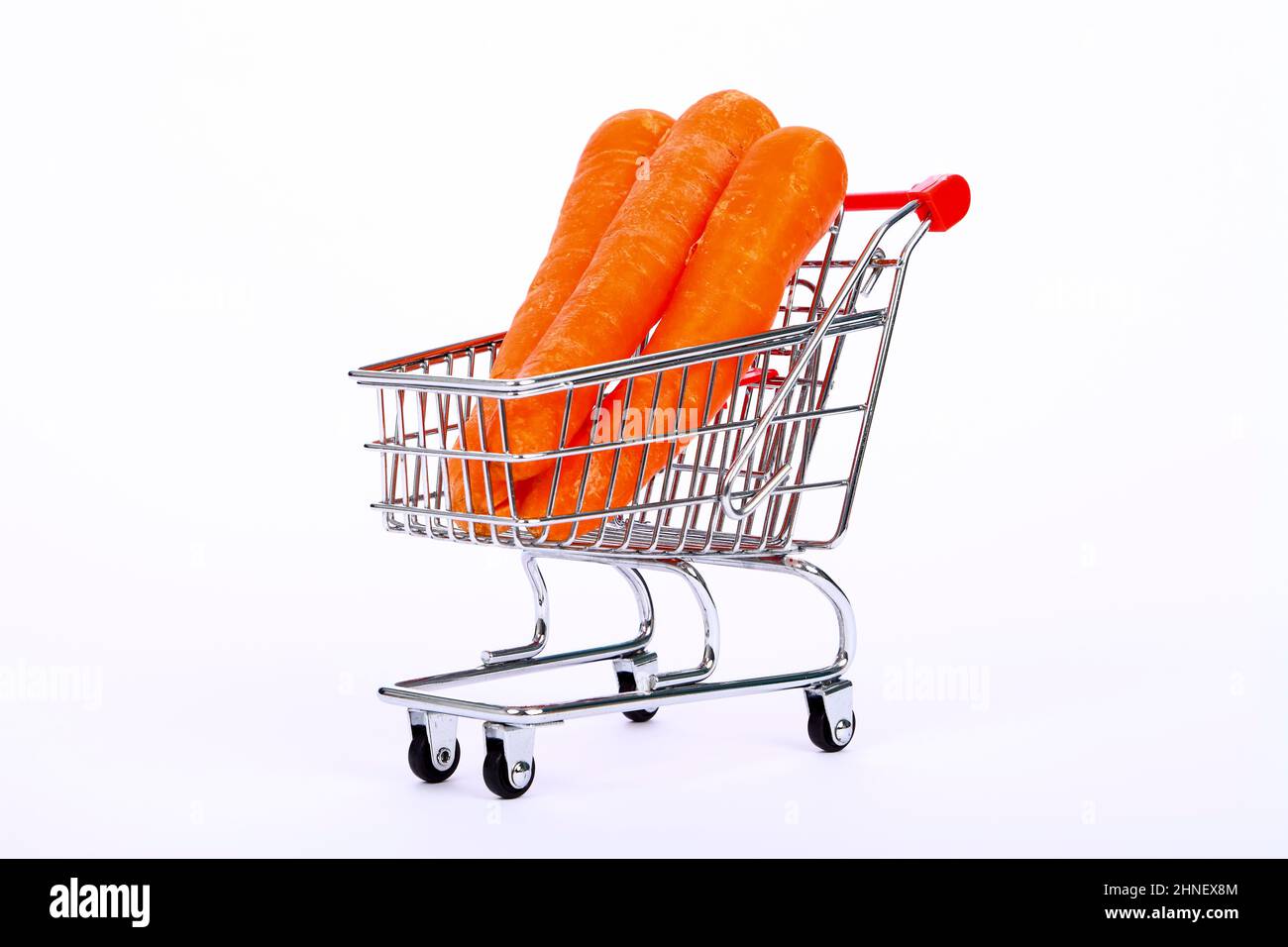 Carrots sat in a miniature wire shopping trolley cart, Healthy eating / Shopping concept Stock Photo