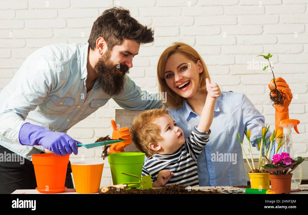 Happy Family planting flowers together. Care for plants. Gardening discovering and teaching. Stock Photo