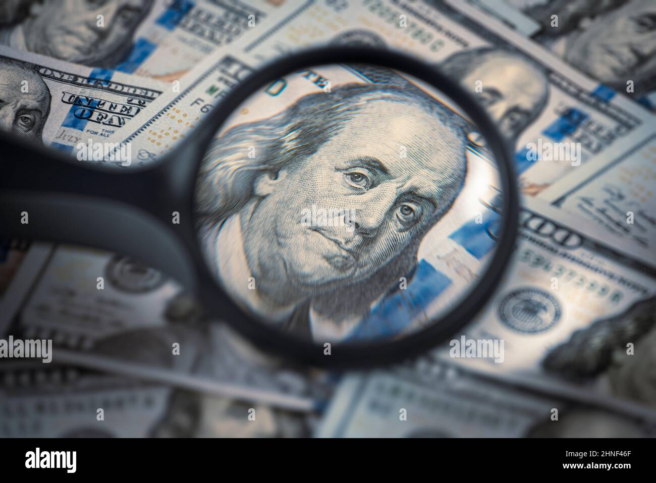 Сlose-up portrait of Benjamin Franklin in a magnifying glass, One hundred dollar bills, finance and capital banking concept Stock Photo