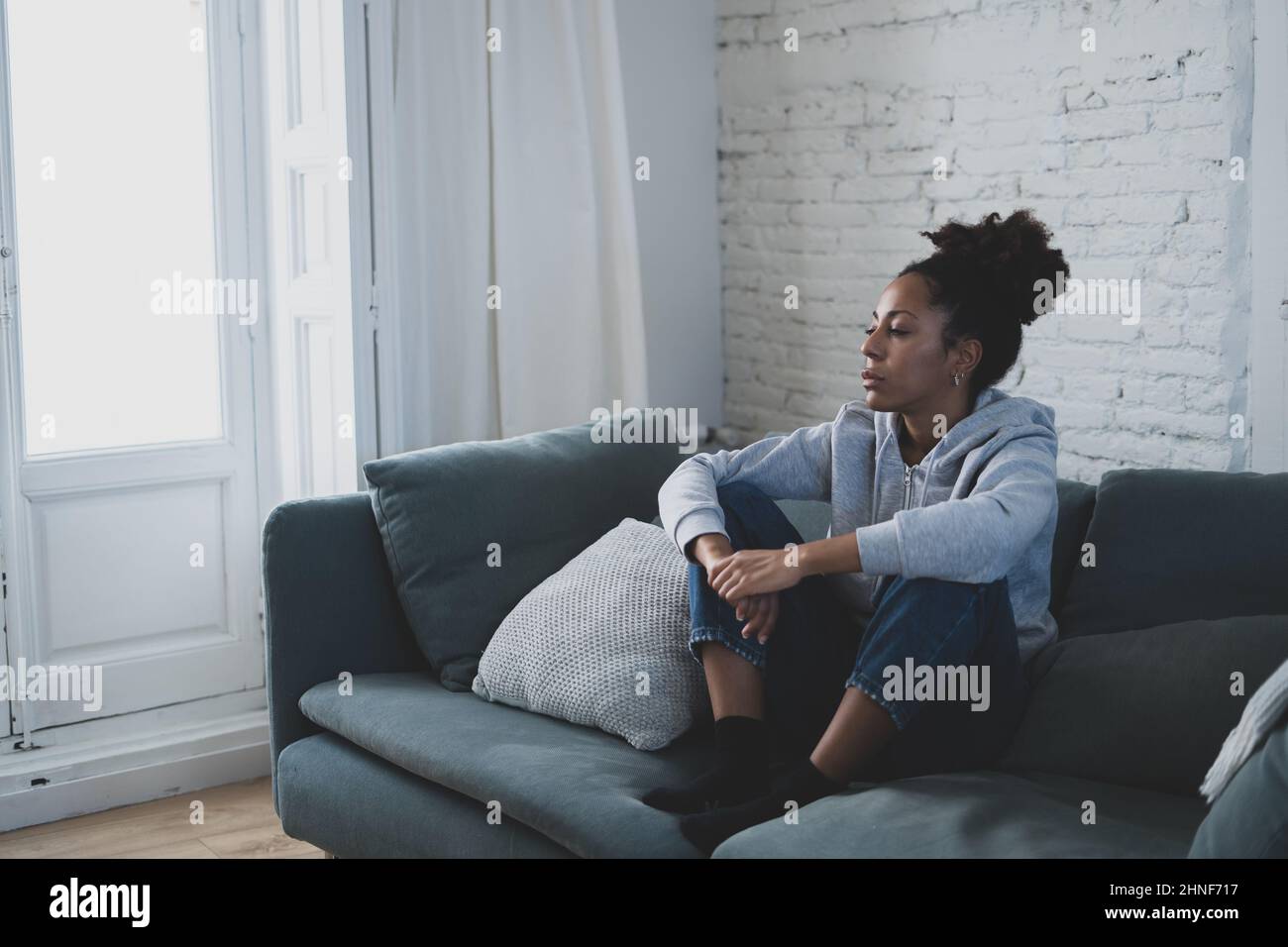 Depressed african woman with sad expression, headache and depression feeling desperate at home. Afro American teen or Attractive black young female ly Stock Photo