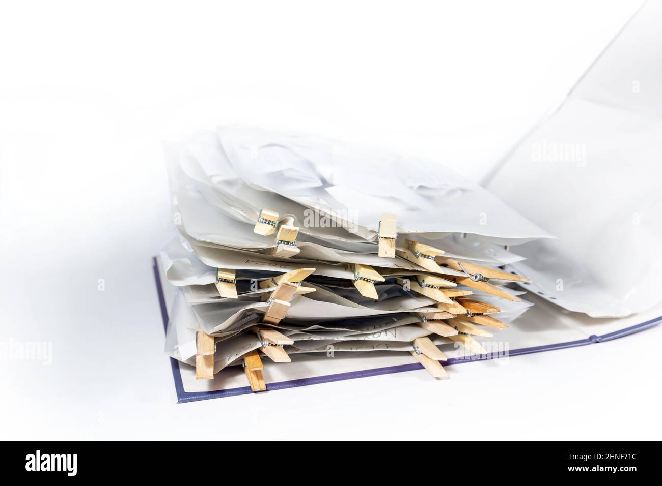 Ring binder or document folder with transparent punched pockets full of receipts closed with wooden clothespins, accounting and tax calculation, offic Stock Photo