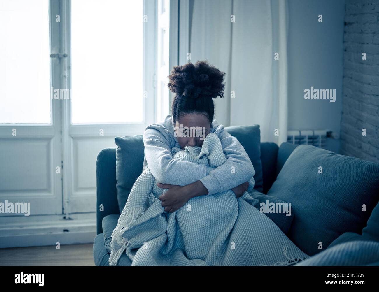 Depressed african woman with sad expression, headache and depression feeling desperate at home. Afro American teen or Attractive black young female ly Stock Photo