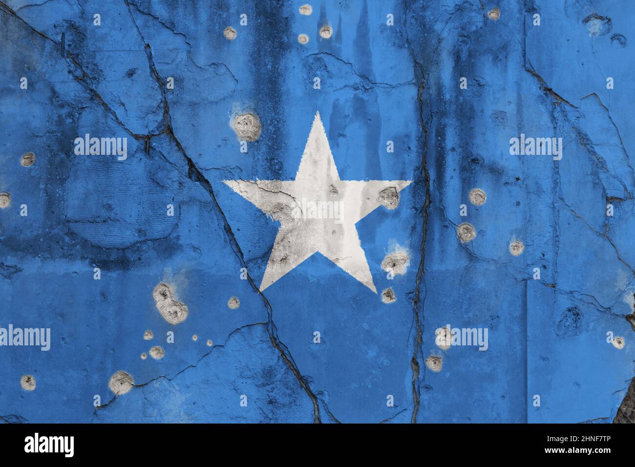 Full frame photo of a weathered flag of Somalia painted on a cracked wall with bullet holes. Somali Civil War, conflict and crisis concept. Stock Photo