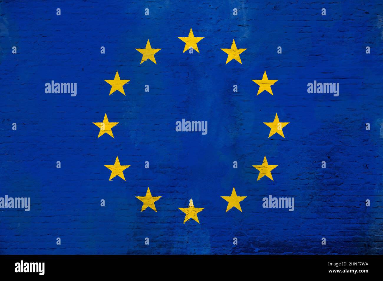 Full frame photo of a weathered flag of Europe (EU, European Union) painted on a plastered brick wall. Stock Photo