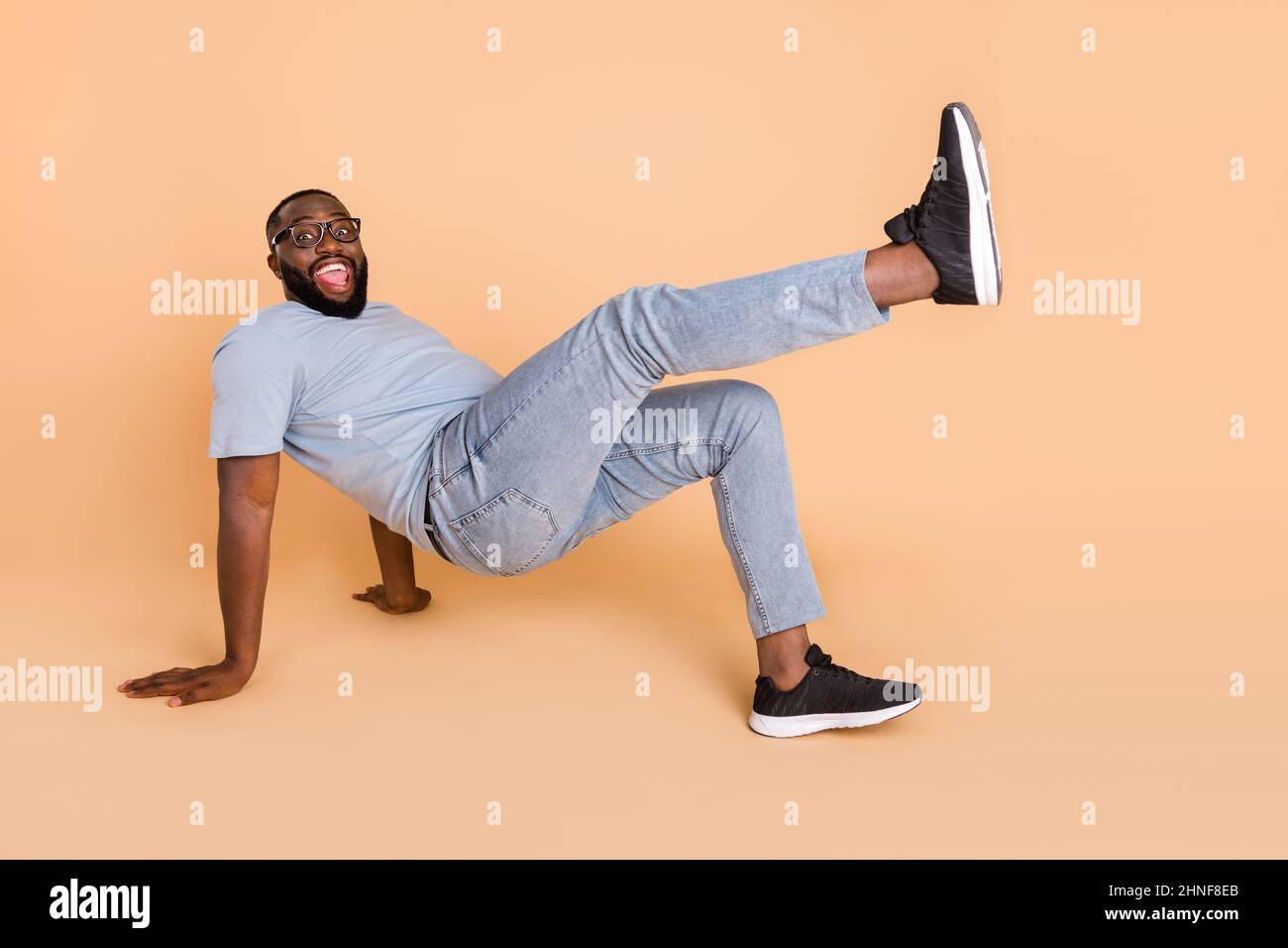 Portrait of attractive cheerful guy dancing break having fun performance isolated over beige pastel color background Stock Photo