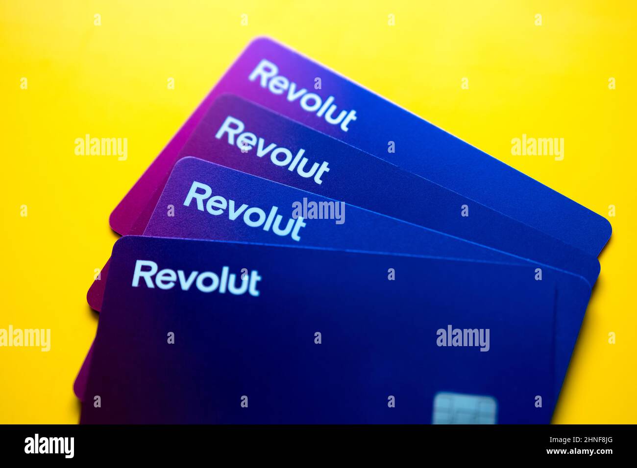 Pile of new Revolut VISA debit cards placed on vibrant background. Selective focus. Stafford, United Kingdom, February 16, 2022. Stock Photo