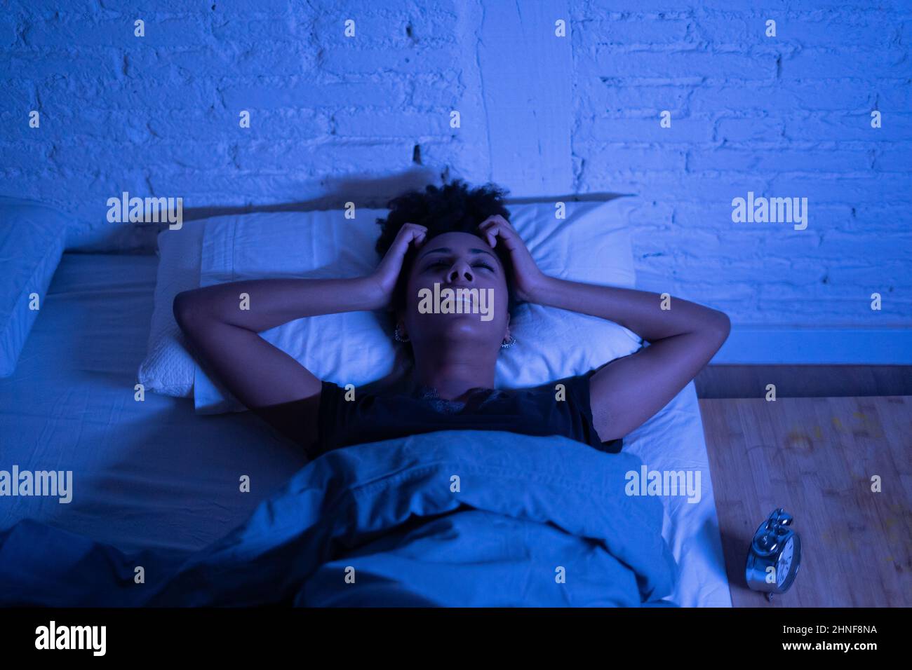 Young beautiful afro american woman at home lying in bed late at night trying to sleep suffering insomnia sleeping disorder or scared on nightmares lo Stock Photo