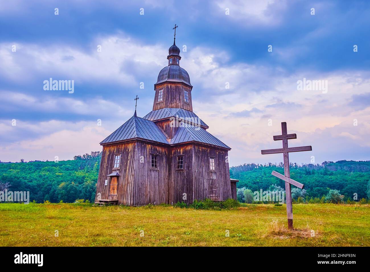 Preserved historical wooden St Nicholas Church and a cross in historical Cossack Village Scansen in Stetsivka village, Ukraine Stock Photo