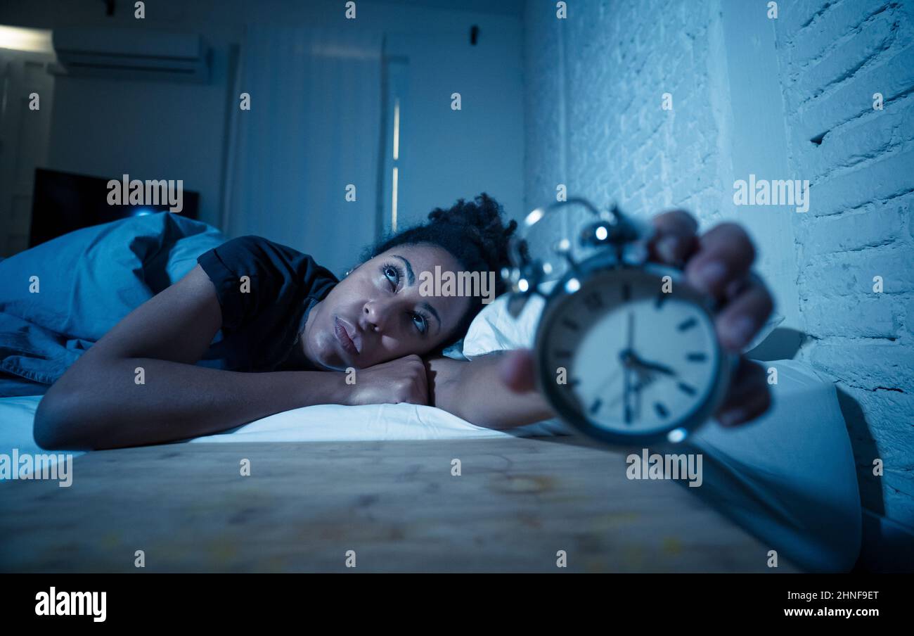 Young beautiful afro american woman at home lying in bed late at night trying to sleep suffering insomnia sleeping disorder or scared on nightmares lo Stock Photo