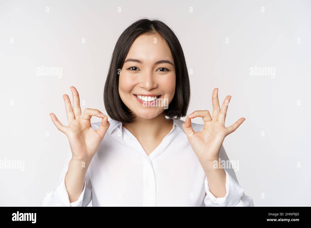 Close up head portrait of asian girl showing okay, ok sign and smiling ...