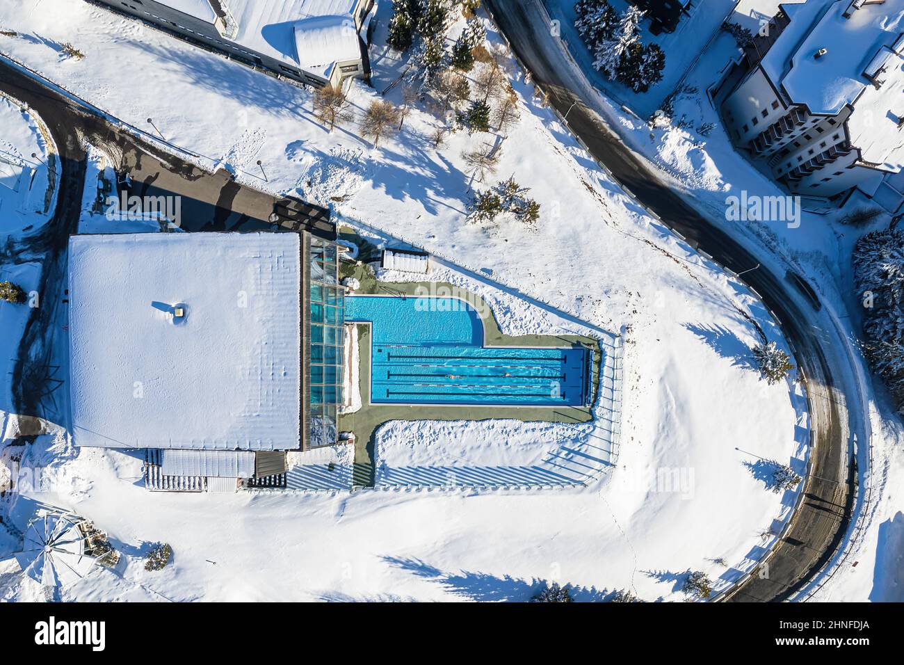 View from the top of a heated outdoor swimming pool in the snow . Sestriere, Italy - February, 2022 Stock Photo