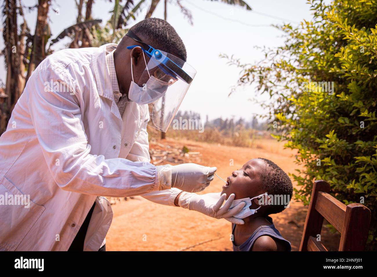 An african doctor does a swab test on a child to see if he positive to coronavirus. Covid-19 test in Africa. Molecular and rapid antigen test Stock Photo