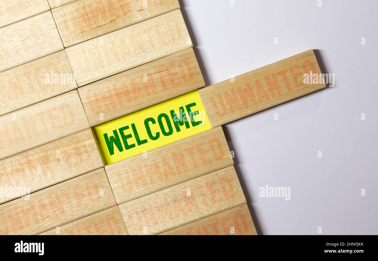 the words welcome and unwanted on the wooden blocks. Stock Photo