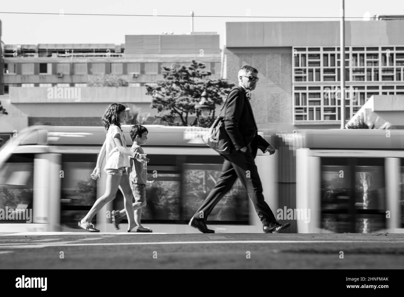 Mobility in the city of Barcelona, tram and people moving around the city at the same time. Stock Photo