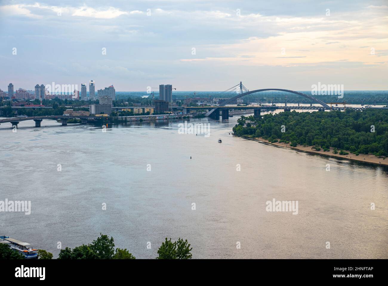 City landscape with bridges over dnipro river against cloudy sky Stock Photo