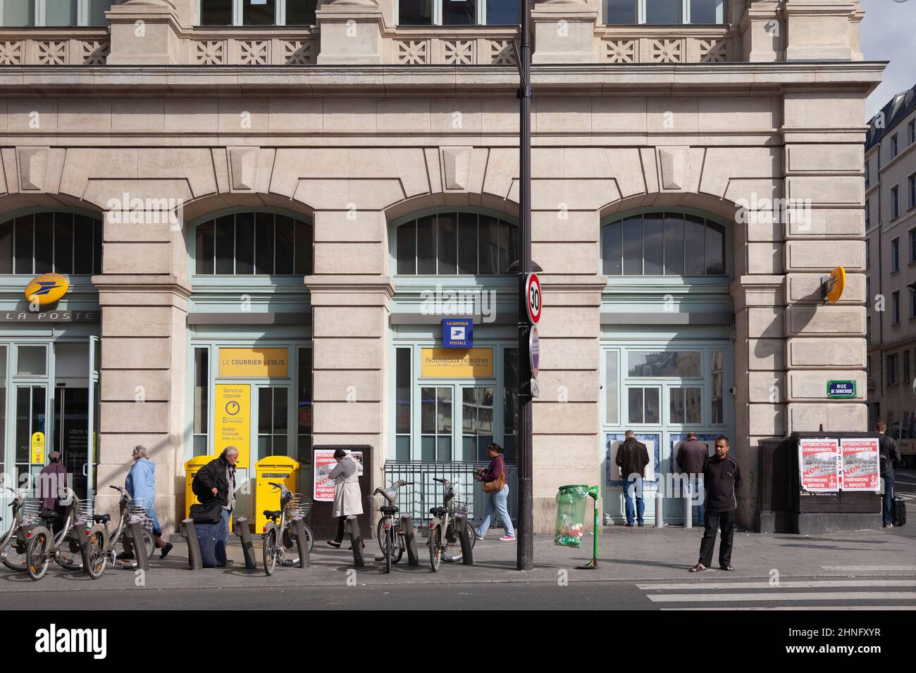 La Poste, the Post office associated with the Gare du Nord station in central Paris, France. Customers and pedestrians are on the pavement outside. A Stock Photo