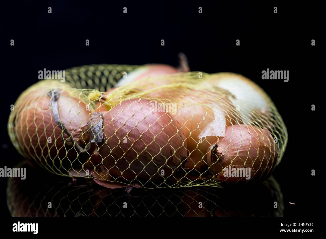 Onion bag cooking with onions. Choosing brown onion for cooking. Stock Photo