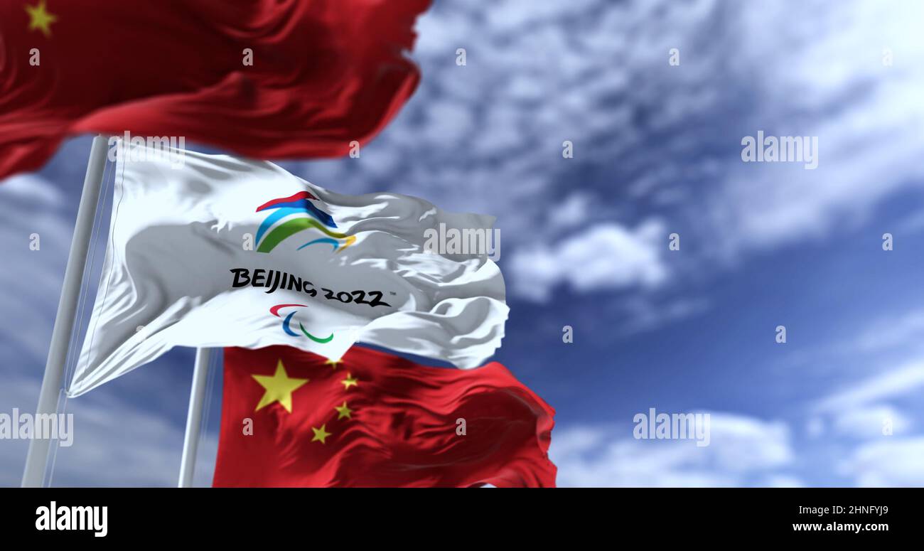 Beijing, China, February 2022: The flag of Beijing 2022 Paralympics waving in the wind with the national flags of China. Winter paralympics games are Stock Photo