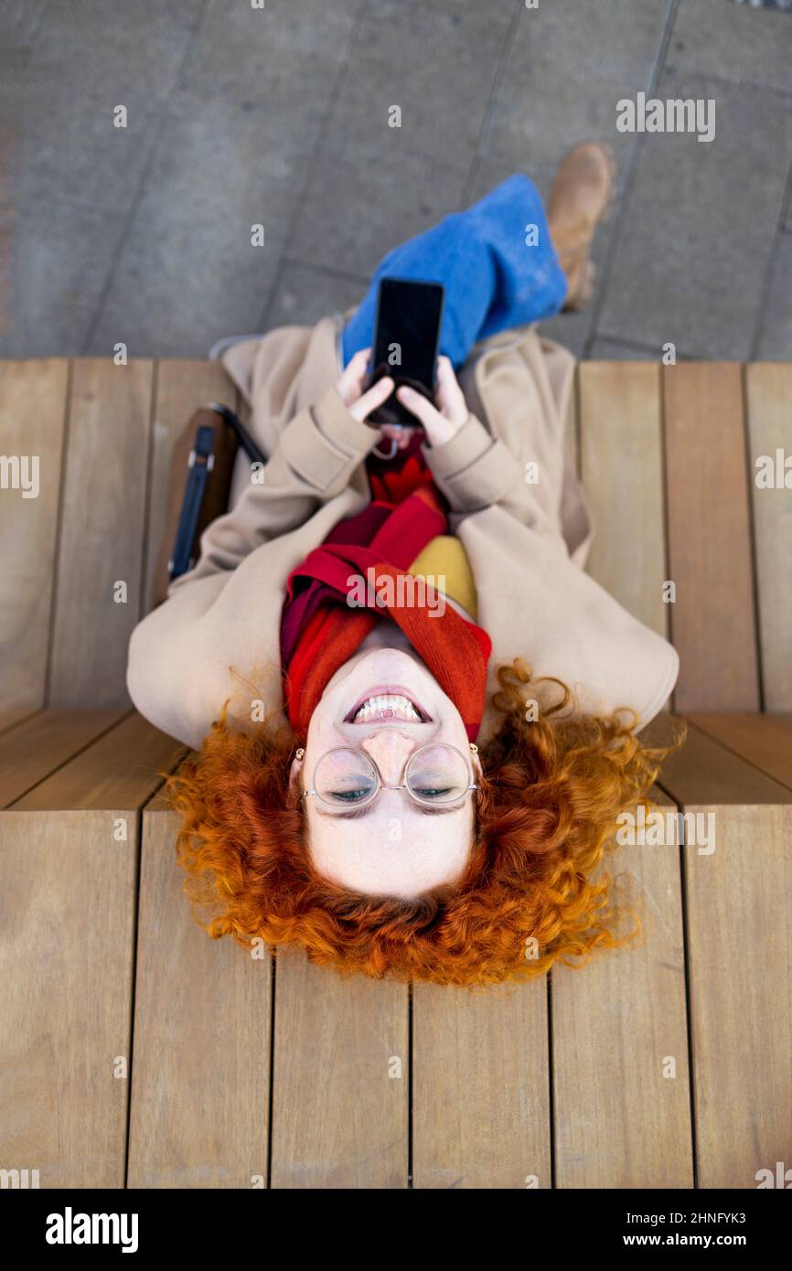 Happy woman using her smartphone to communicate with her friends Stock Photo