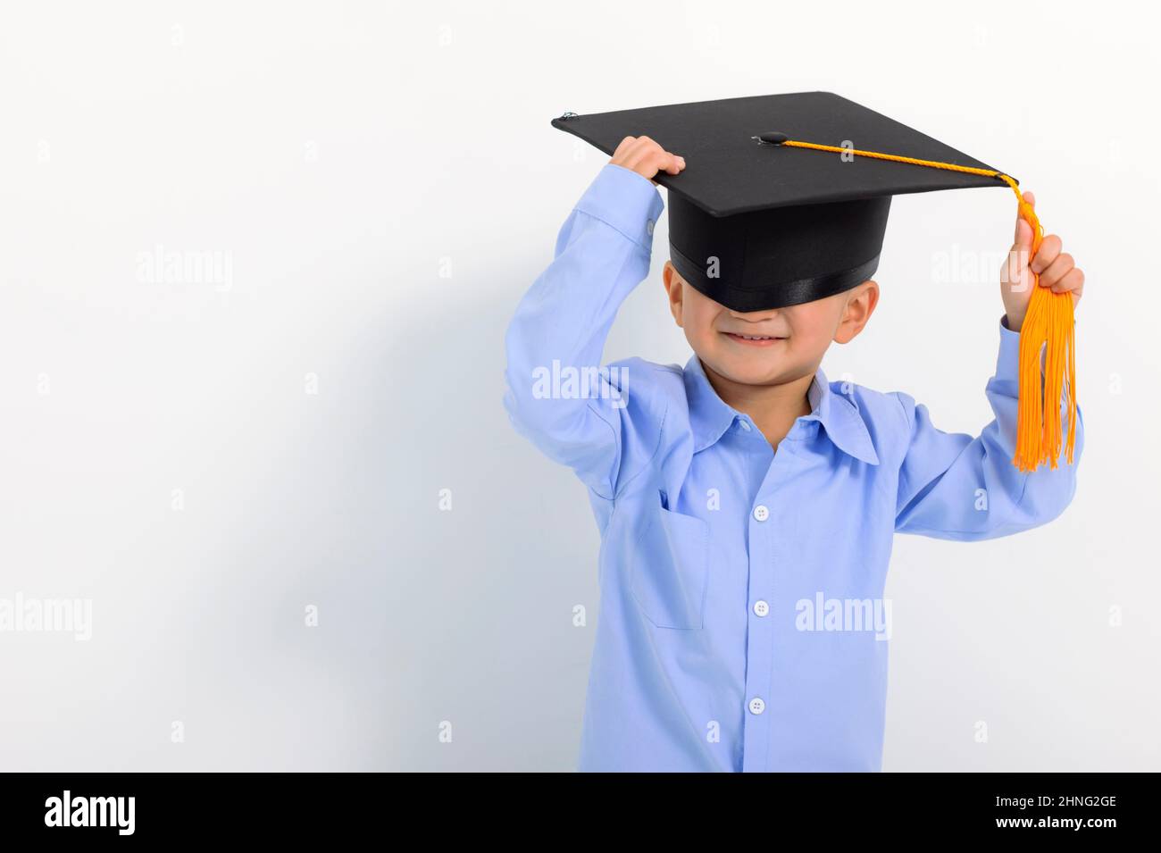 Happy Kid boy in graduation cap and cover eyes Stock Photo