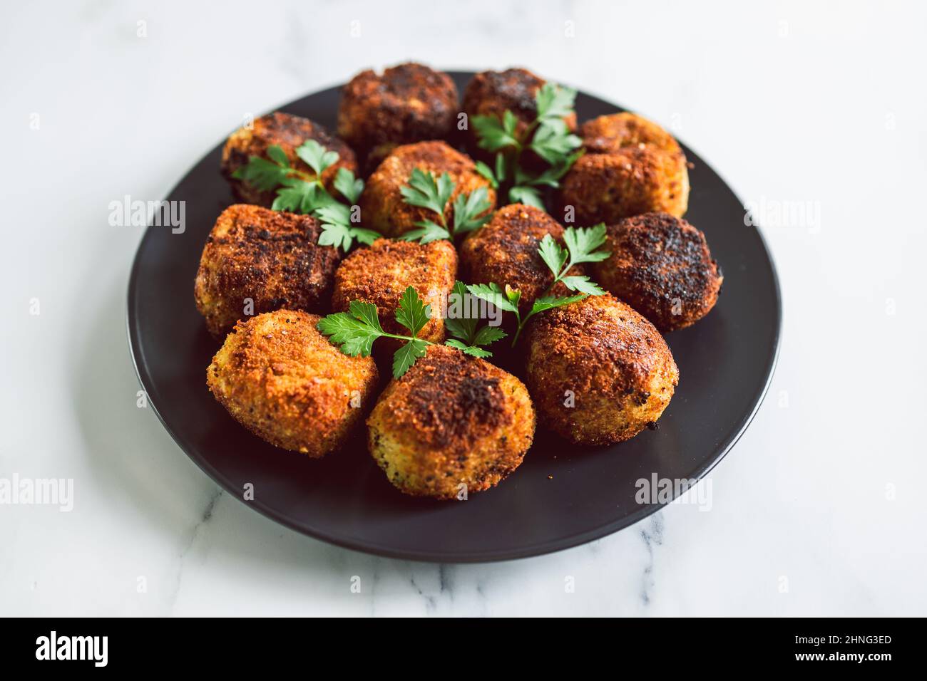 vegan pesto arancini fried risotto balls with fresh parsley as topping