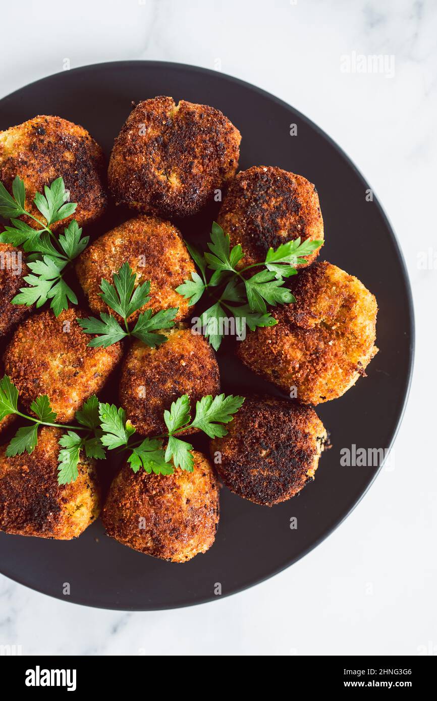 vegan pesto arancini fried risotto balls with fresh parsley as topping