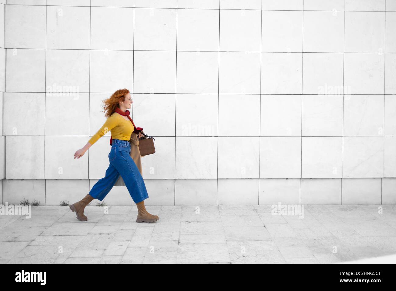 Confident young woman walking fast on her way to work Stock Photo