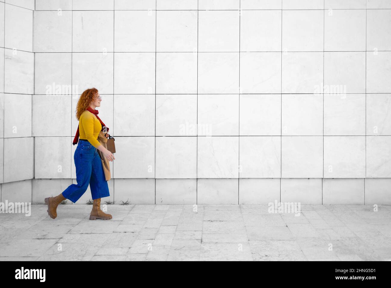Young curly woman walking fast in a big city Stock Photo