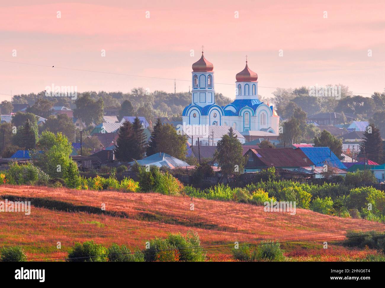 Pokrovsky Alexander Nevsky convent in Kolyvan. late XIX century. Orthodox Church with a bell tower in the middle of a Siberian village. Autumn landsca Stock Photo