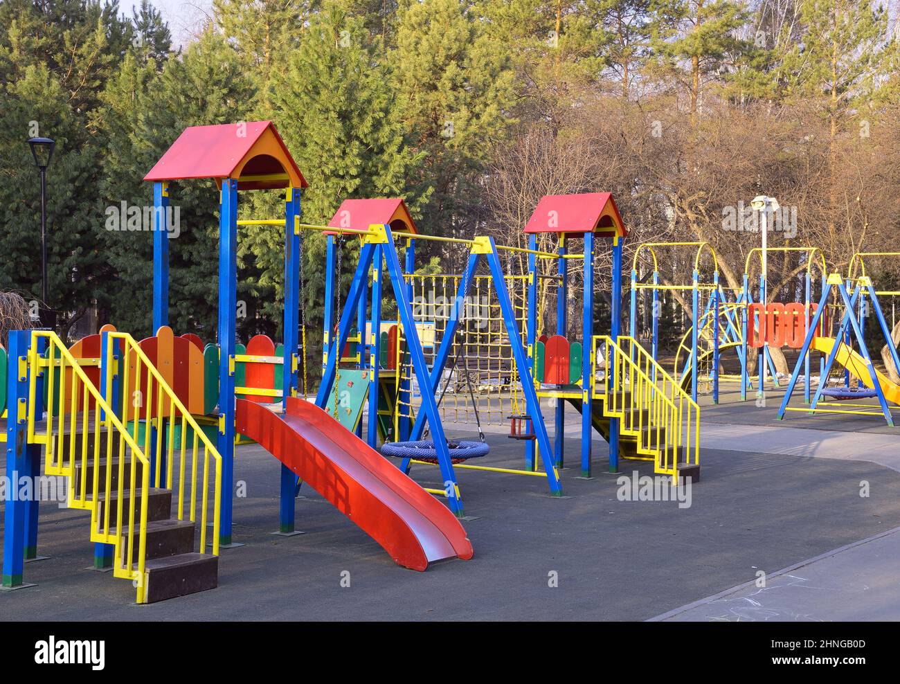 Children's playground in the park. Colorful swings, slides, ladders, horizontal bars on an empty playground in the morning. Novosibirsk, Siberia, Russ Stock Photo