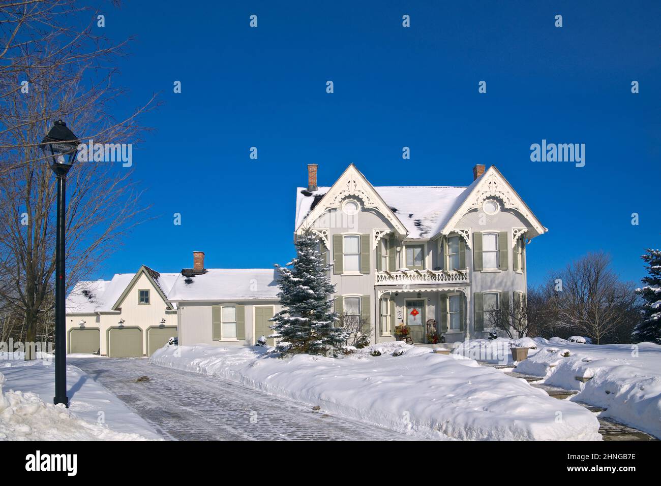 Victorian-style house exterior with street lamp in winter. Stock Photo