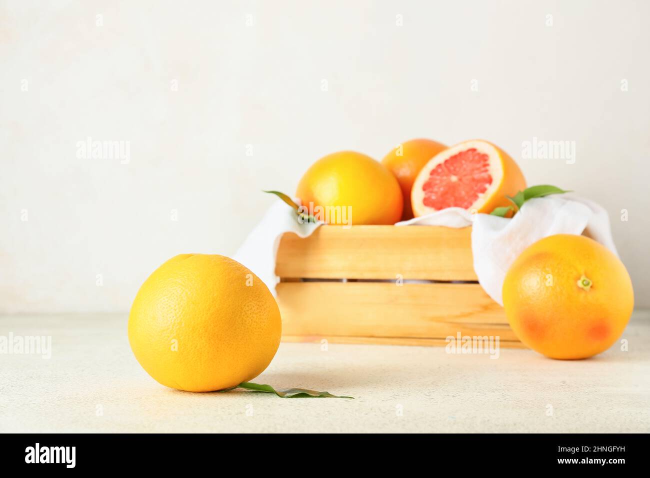 Box with delicious grapefruits on light background Stock Photo